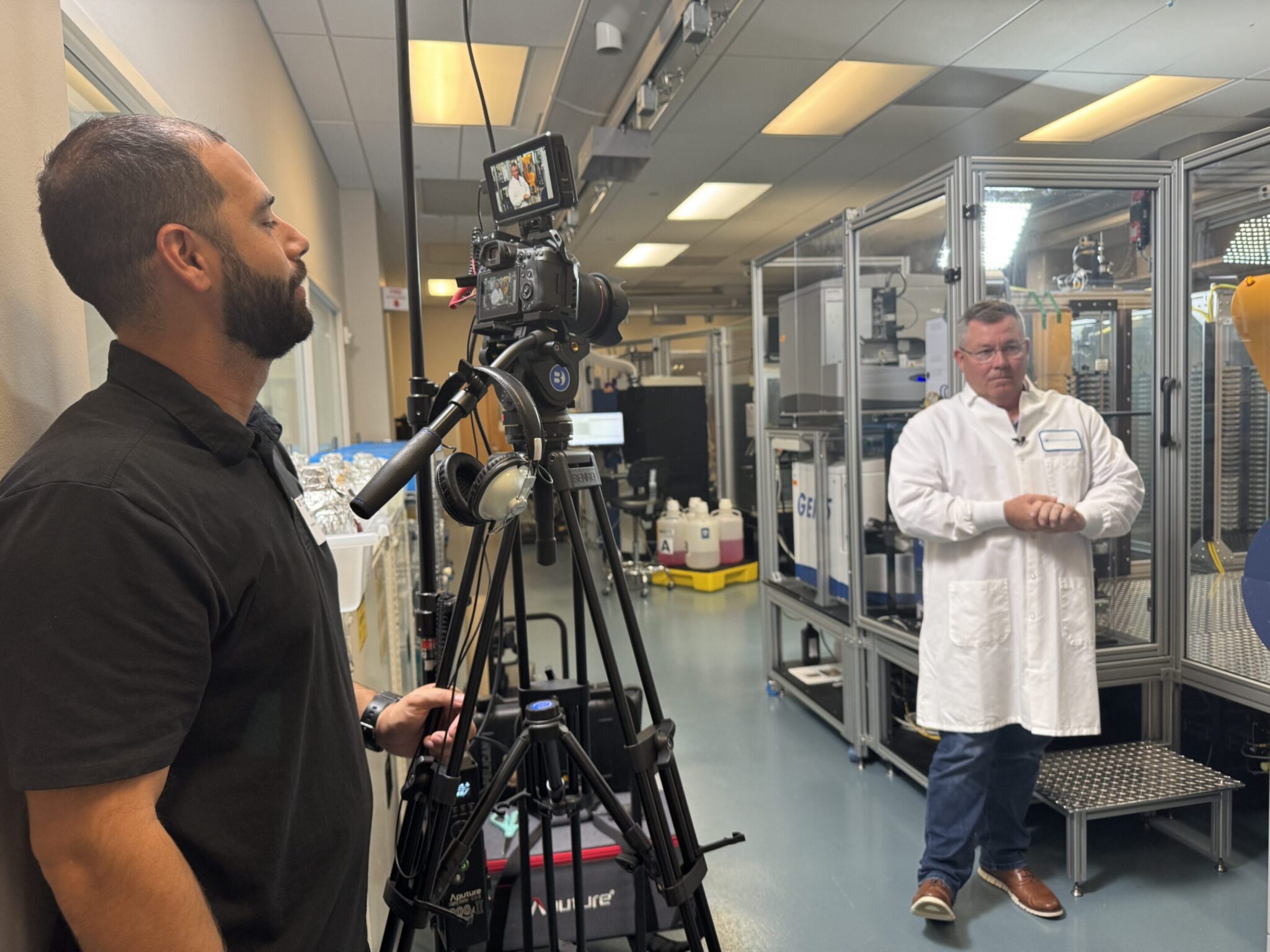 Cameraman filming a scientist in a laboratory.